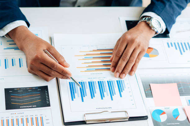 istock Business man is checking and auditing the business performance with a help from his college. Analyzing the revenue and auditing the budget concept. 1341621973