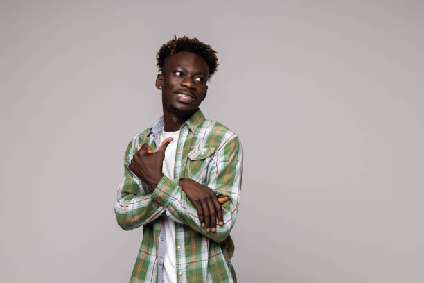 istock Young african american man pointing sideways over white background 1341622687