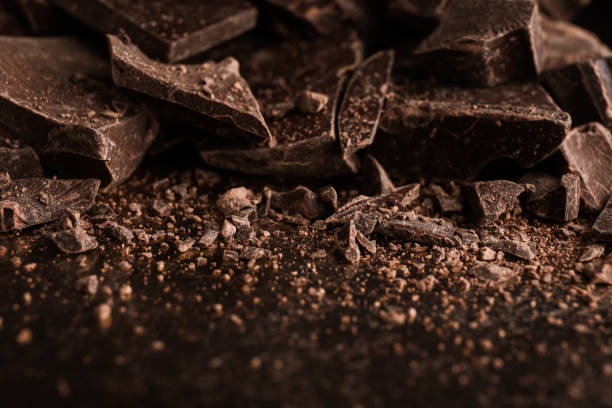 istock Pieces of dark chocolate on black table, closeup 1341623002