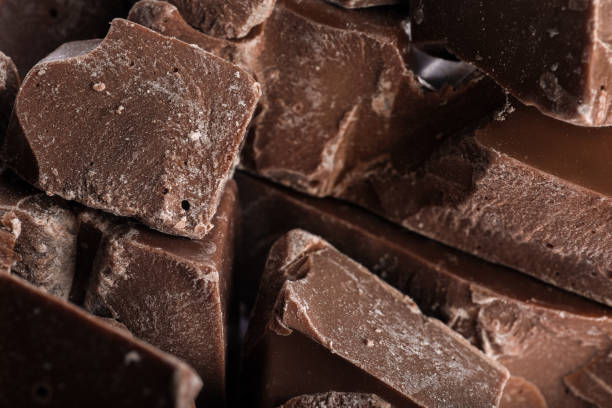 istock Pieces of milk chocolate as background, closeup 1341623126
