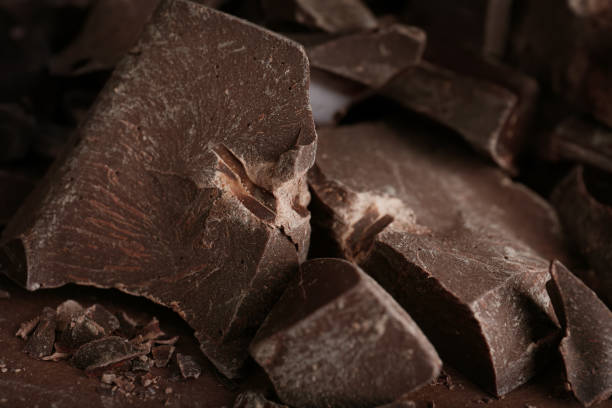 istock Pieces of dark chocolate on brown table, closeup 1341623448