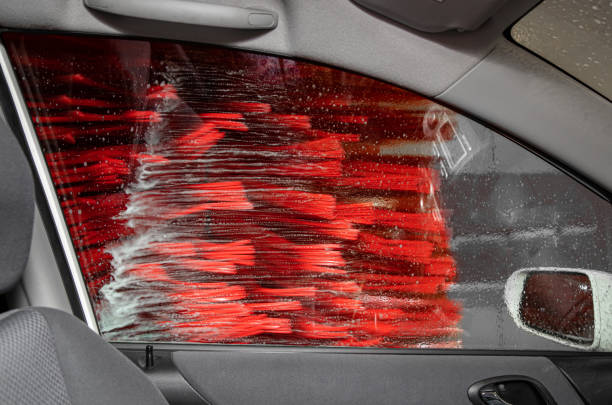 istock Looking out the passenger window inside automate car wash service, brushes are spinning and cleaning the car. Car wash concept. 1341624643