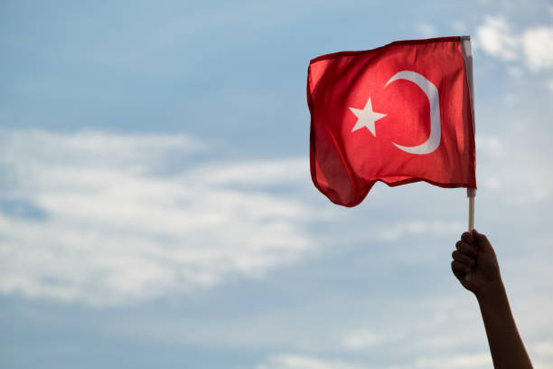 primer plano de una bandera turca ondeando en la mano. - turquia bandera fotografías e imágenes de stock