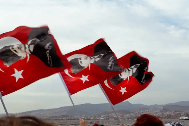 Izmir, Turkey - September 9, 2021: Crowded people waving Turkish flags which Ataturk photo on them on the liberty day of Izmir