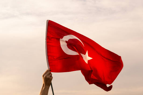Close up shot of a waving Turkish flag on hand. Close up shot of a hand held Turkish flag waving on a warm cloudy sky. number 19 stock pictures, royalty-free photos & images