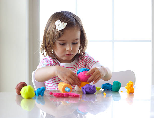 niña jugando con juegos masa - food child childs play clay craft fotografías e imágenes de stock