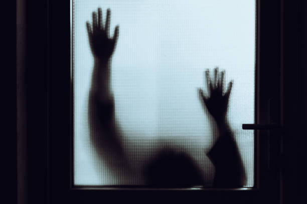 istock Domestic abuse victim with hands pressed against glass window 1341625854