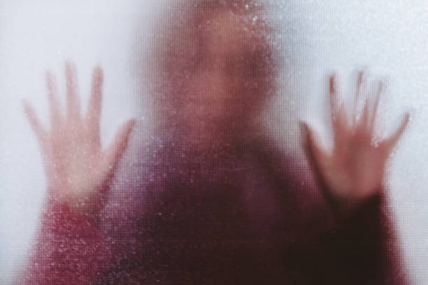 istock Domestic abuse victim with hands pressed against glass window 1341625861