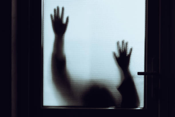istock Domestic abuse victim with hands pressed against glass window 1341625889