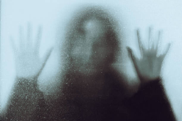 istock Domestic abuse victim with hands pressed against glass window 1341625941