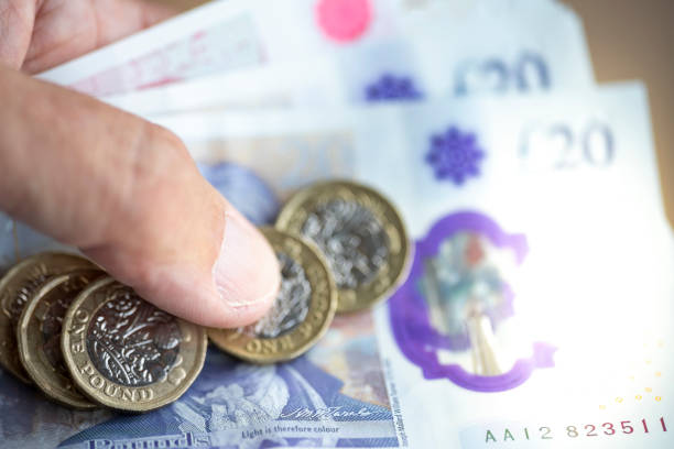 istock A man's hand holding £50 and £20 pound notes and pound coins 1341626398