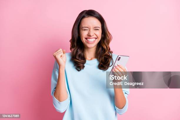 Photo Of Young Excited Crazy Girl Fists Hand Celebrate Win Victory Success Use Cellphone Isolated Over Pink Color Background Stock Photo - Download Image Now