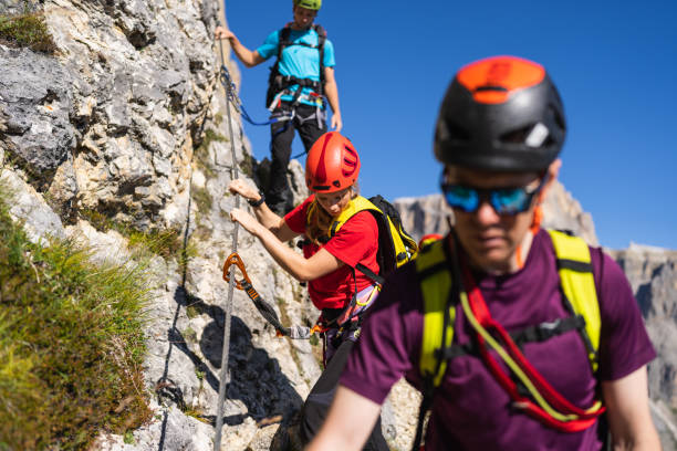 istock Alpine mountain guide climbing on via ferrata with hiking group 1341627581