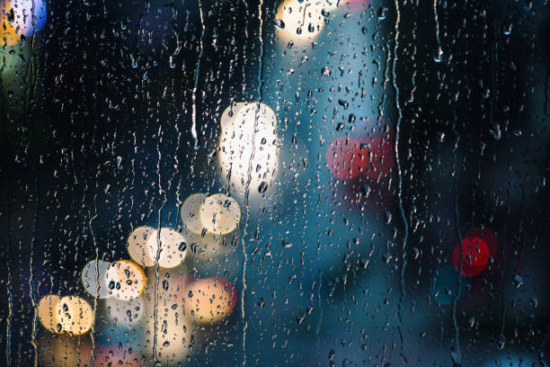 istock Abstract raindrops on window with colorful bokeh from city traffic 1341627662