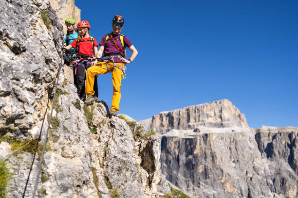 istock Alpine mountain guide climbing on via ferrata with hiking group 1341628819