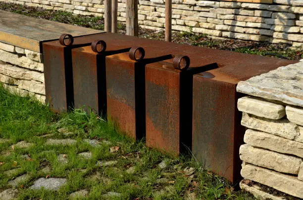stone marl walls with stone cladding by the pool, ponds, fire tanks. metal bike racks and trash cans included in the wall. rusty corten steel railing, beige lime pavement, cor-ten, marl,