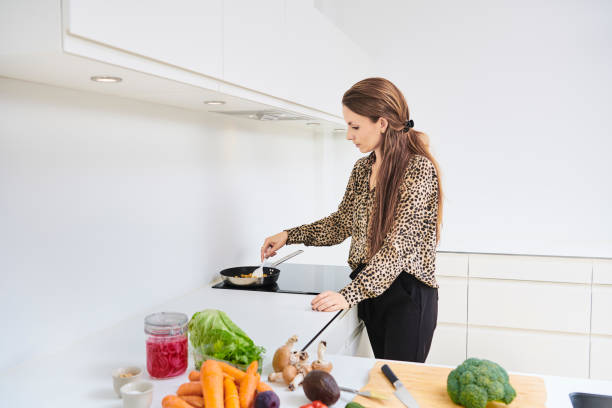 istock Young woman in kitchen preparing a vegan meal 1341632967