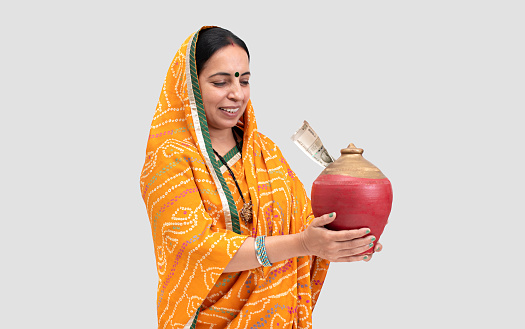 Adult, adult only, real people, middle class, India, Indian ethnicity,Lady in saree, Piggy Bank