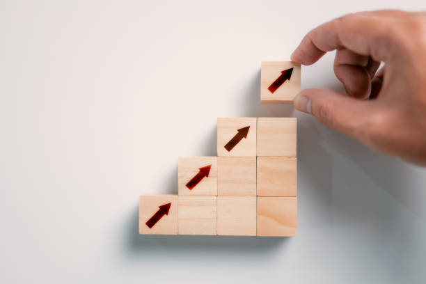 istock Business concept growth success process, Close up hand arranging wood block stacking as step stair on paper white background with copy space. 1341634348