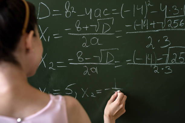 istock serious female teacher explain math formulas in university beside blackboard 1341634853
