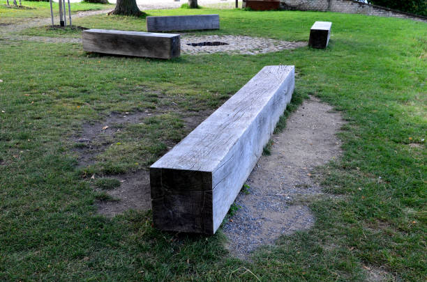 istock wooden massive park bench shape block on granite natural cobblestone irregular chipped brown gray pavement, oak wood prism painted from one piece trunk, circle fireplace, viewpoint, yard, celtic 1341635277