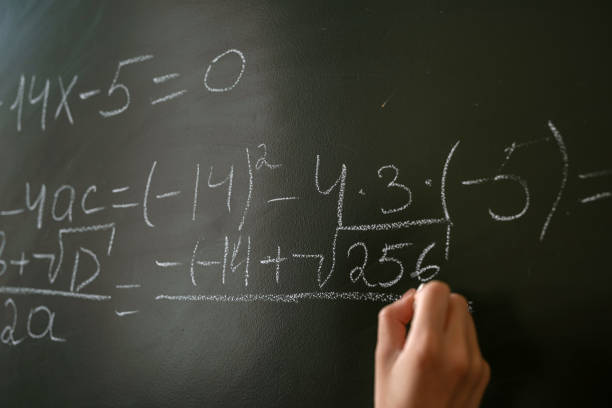 istock serious female teacher explain math formulas in university beside blackboard 1341635297