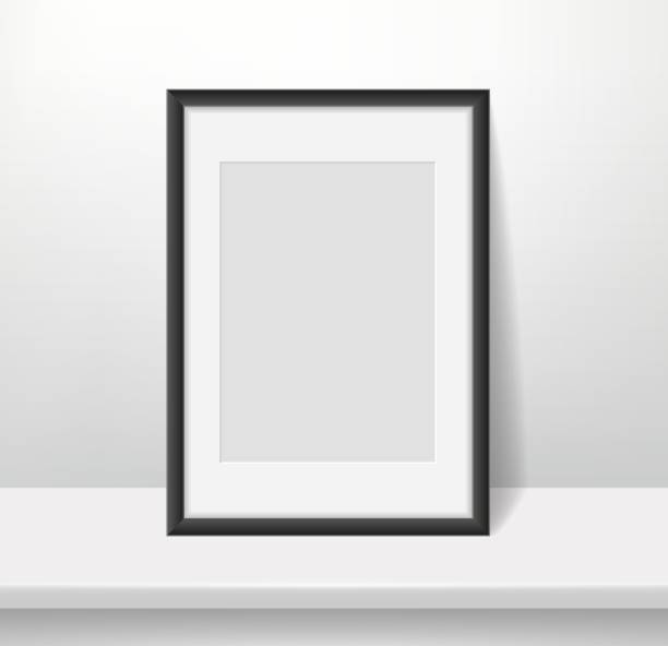 istock Realistic frame on wall background. Blank framed picture or poster mockup, dark plastic border with paspartu, vertical a4 photo format, interior design accessory, vector concept 1341637284