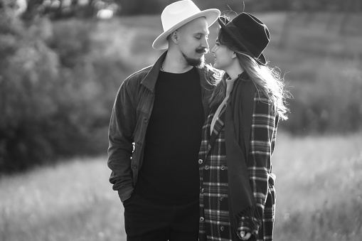 Black and white photo of  romantic couple in love walking  in the autumn park. Love story. Autumn style. Kiss and hugs.