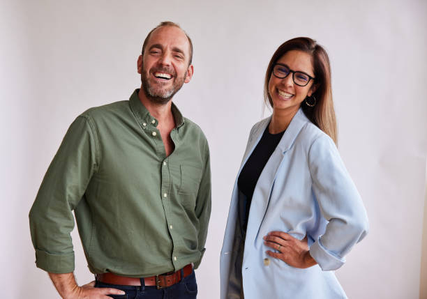 istock Two businesspeople laughing together against a white background 1341641488