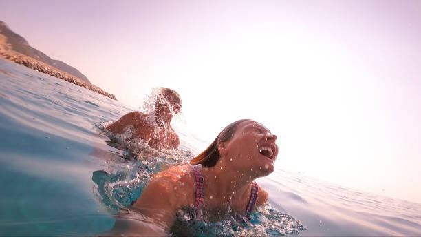 vista di padre e figlia che nuotano nel mare - splashing color image front view head and shoulders foto e immagini stock