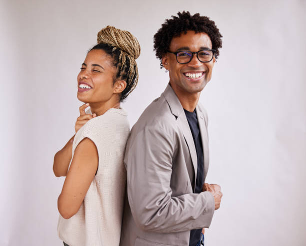 istock Laughing young businesspeople standing back to back against a white background 1341642886