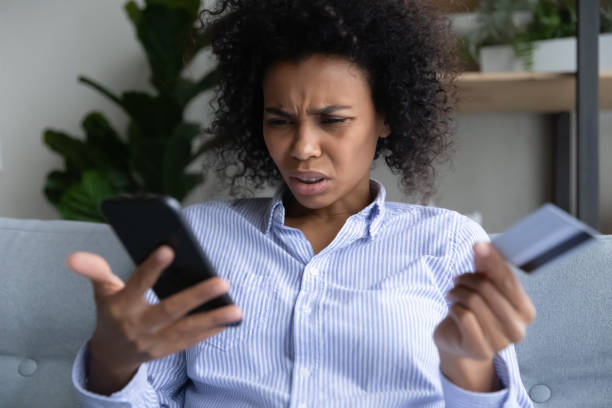 istock Young black woman having problems with paying online by card 1341643974
