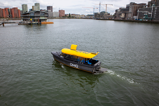Rotterdam, The Netherlands - September 13, 2021: A watertaxi on River Maas at Port of Rotterdam. The watertaxis connect 50 landing stages in Rotterdam and the surrounding area.