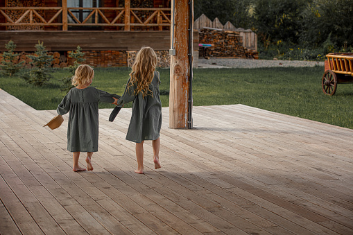 Two small beautiful children girls walking together in the countryside