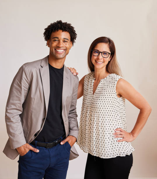 istock Two diverse young businesspeople smiling against a white backdrop 1341645363