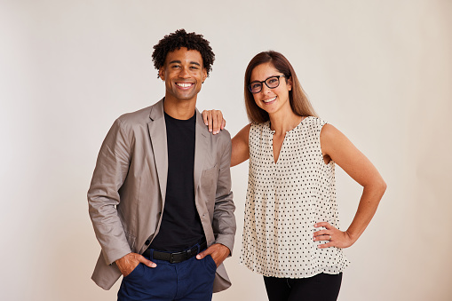 Diverse young businesspeople standing on a white background and smiling