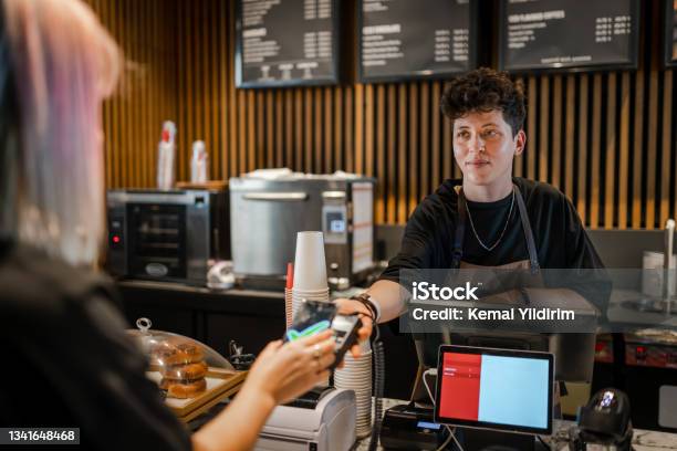 Smiling Barista Taking Fast And Easy Payment In The Coffee Shop Stock Photo - Download Image Now