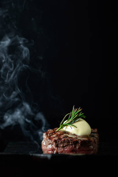 istock Cooking beef tenderloin steak on a grill pan on a black dark background with the text copy space. The concept of the recipe, filet Mignon 1341649717