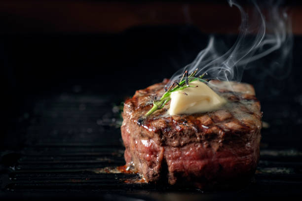 a steaming beef tenderloin steak is grilled in a grill pan with the text copy space. the concept of the recipe , filet mignon - red meat meat dish grilled rare imagens e fotografias de stock