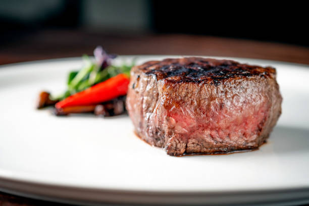 стейк из говяжьей вырезки на гриле на белом блюде с овощами подается в ресторане. - steak filet mignon beef fillet steak стоковые фото и изображения
