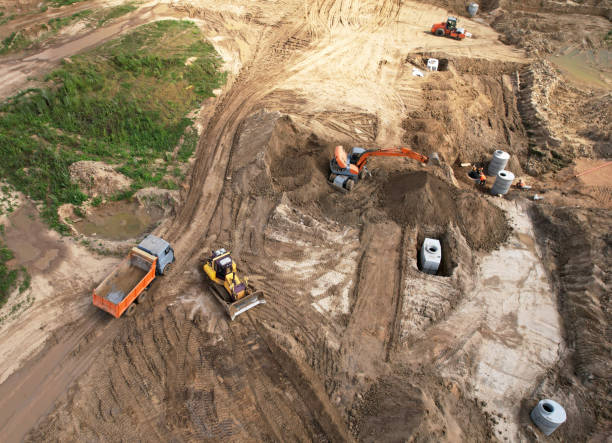 istock Laying a concrete well ring and sewer pipe at construction site. 1341650364