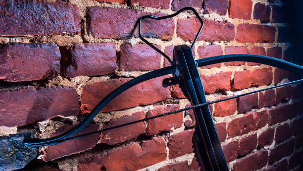 istock A modern compound crossbow handgun on the red brick wall background. Old weapon concept. 1341650517