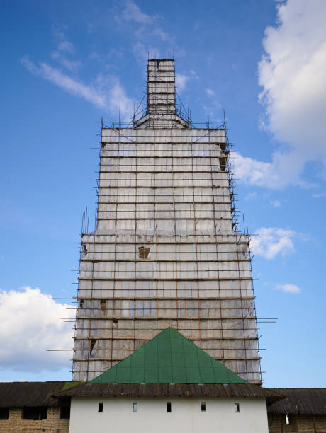 istock Scaffolding from planks around old bell tower. Background blue sky with clouds. 1341650766