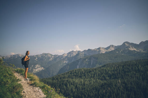 istock Female hiker follows trail along mountain ridge 1341650774