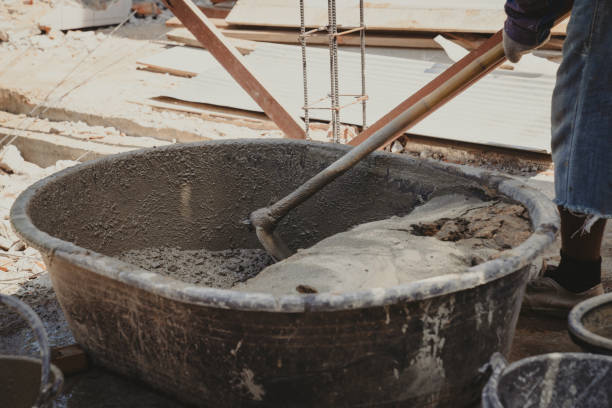 istock Worker man house builder mix mortar from a trough in bucket 1341650828