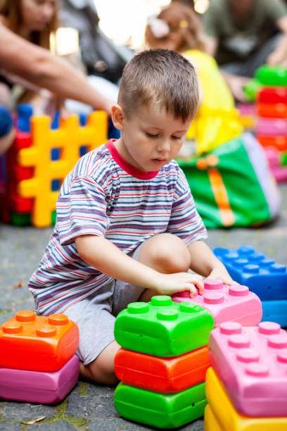 Cute boy playing with buiding toy colorful blocks. Kid with happy face playing with plastic bricks. Plastic Large Toy. Cute boy playing with buiding toy colorful blocks. Preschool activities and early childhood education. Kid with happy face playing with plastic bricks. Plastic Large Toy. maxi length stock pictures, royalty-free photos & images