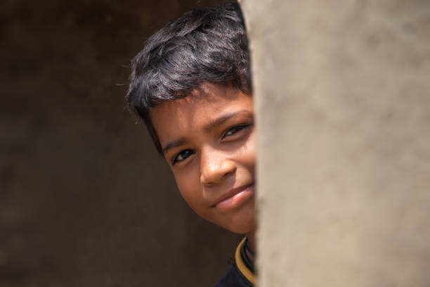 istock Indian rural boy Peeking from Earthen wall 1341651892