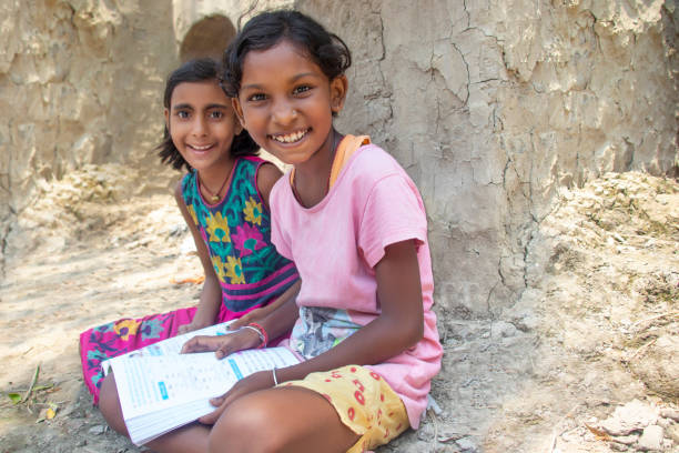 dos niñas rurales indias leyendo libros en casa - bengala del oeste fotografías e imágenes de stock