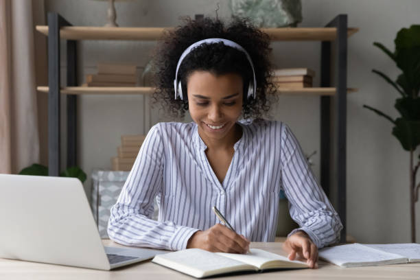 istock Busy young black woman in headset engaged in remote learning 1341655600