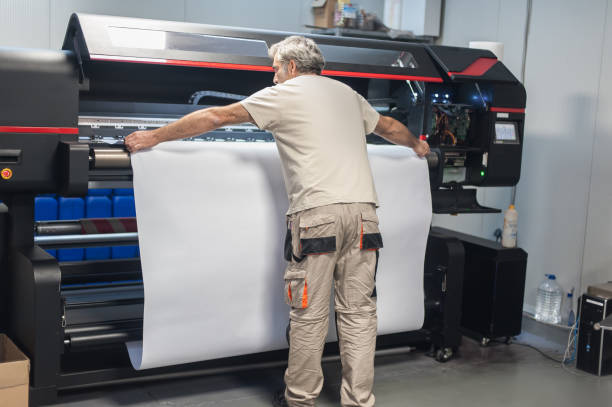 operador técnico trabalha em máquina de plotter de impressora industrial grande prêmio - printing press design computer graphic printer - fotografias e filmes do acervo